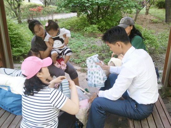                                                                                                ▲ 김진곤 경관이 북한이탈여성들에게 유아복을 기부하고 있다.                                          
