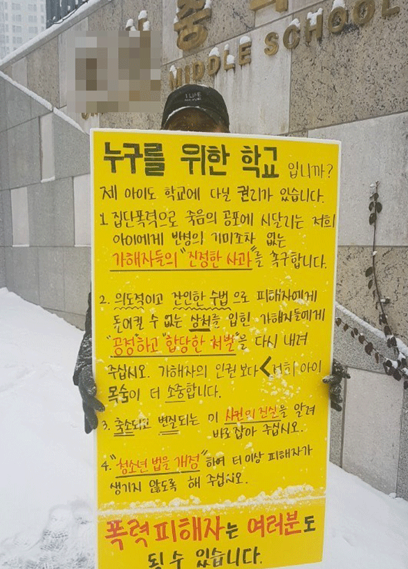 							중학생 집단폭행 사건의 피해자의 어머니 김모씨가 18일 C중학교 앞에서 가해자의 진정한 사과와 처벌을 촉구하는 1인 시위를 하고 있다.