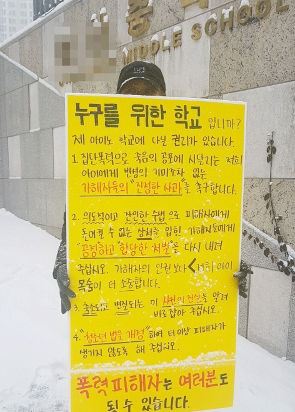 							중학생 집단폭행 사건의 피해자의 어머니 김모씨가 작년 12월 C중학교 앞에서 가해자의 진정한 사과와 처벌을 촉구하는 1인 시위를 하는 모습.