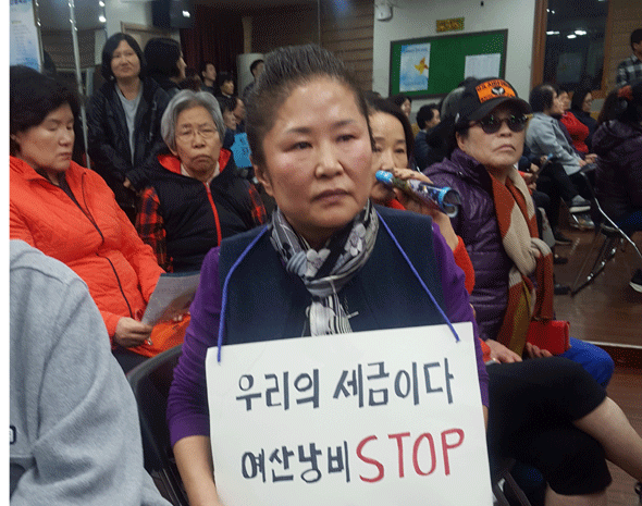 							지난 10월 11일 '광명7동 신나는 어린이공원 지하주차장 조성사업' 공청회에서 한 주민이 사업을 반대하는 피켓을 목에 걸고 있다.