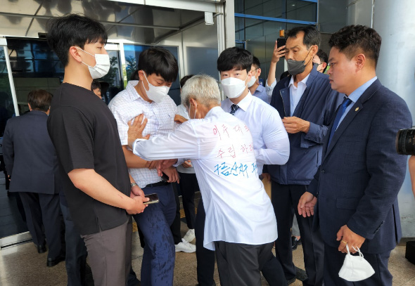 							구름산지구 주민 K씨가 박승원 광명시장 취임식장 진입을 제지당하자 공무원들과 몸싸움을 하고 있다.